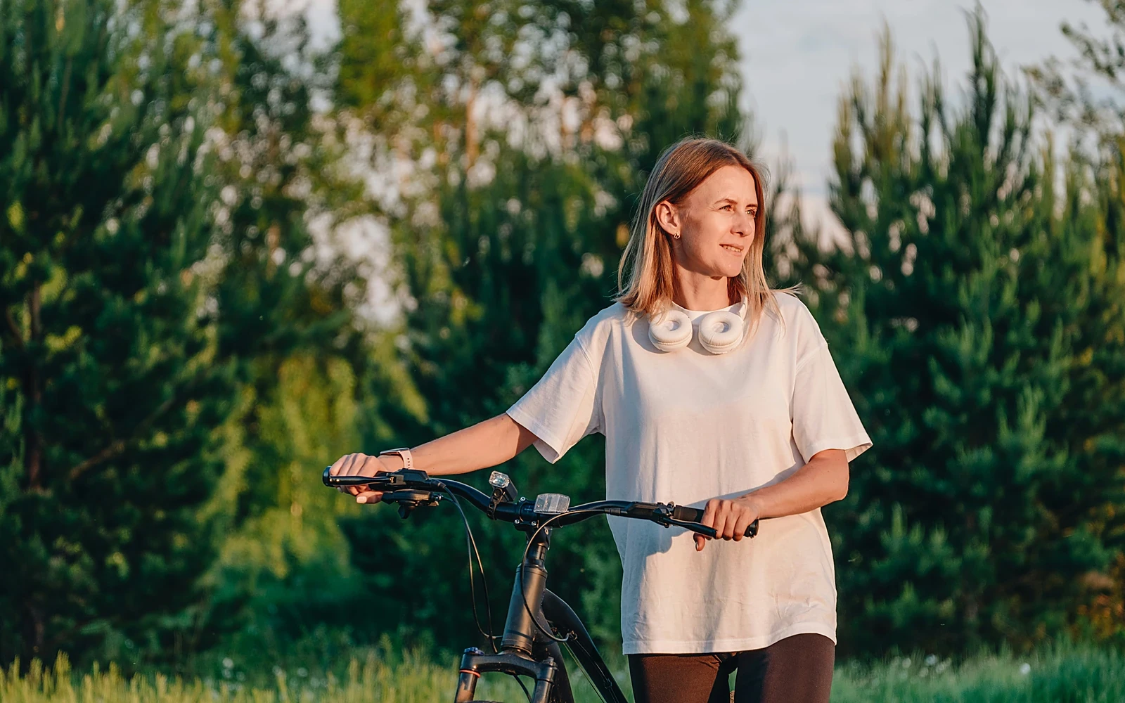 A woman with her bicycle at golden hour