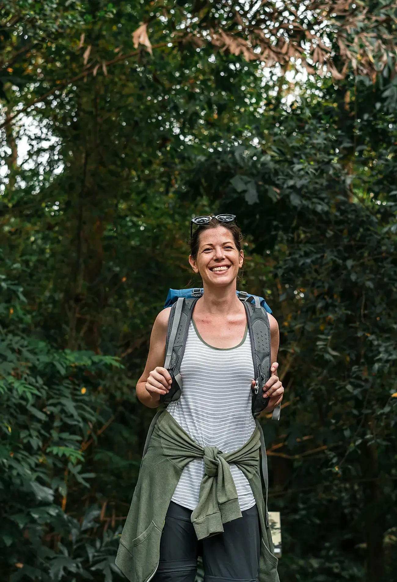 A smiling woman on a forest hike