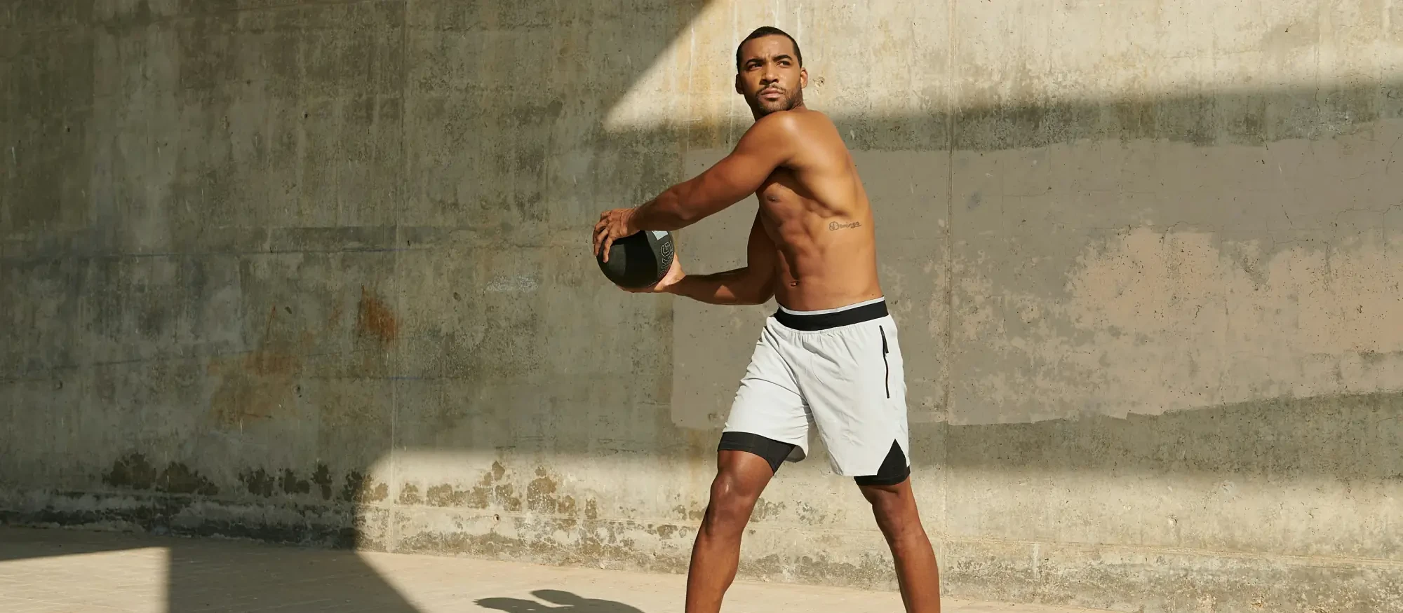 A man swinging a medicine ball mid-workout