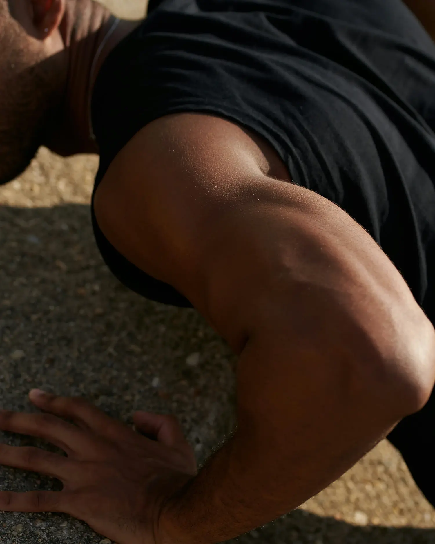 A man pushing through the last rep of a push-up in the sun